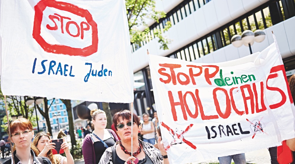 Ein Foto einer Demo mit Transparenten »Stop Israel Juden« und »Stopp deinen Holocaust Israel«.